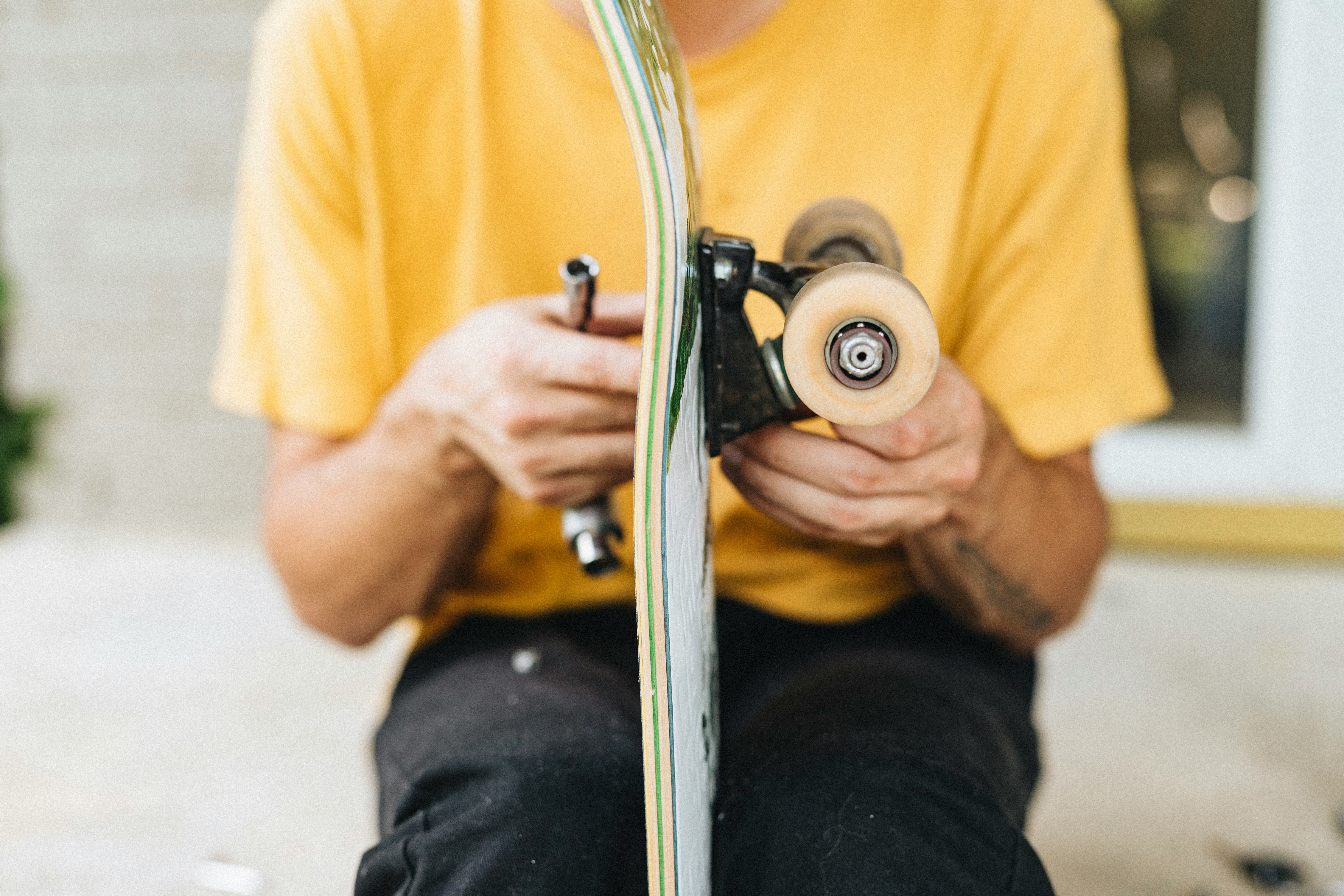 man in yellow shirt holding white and black camera